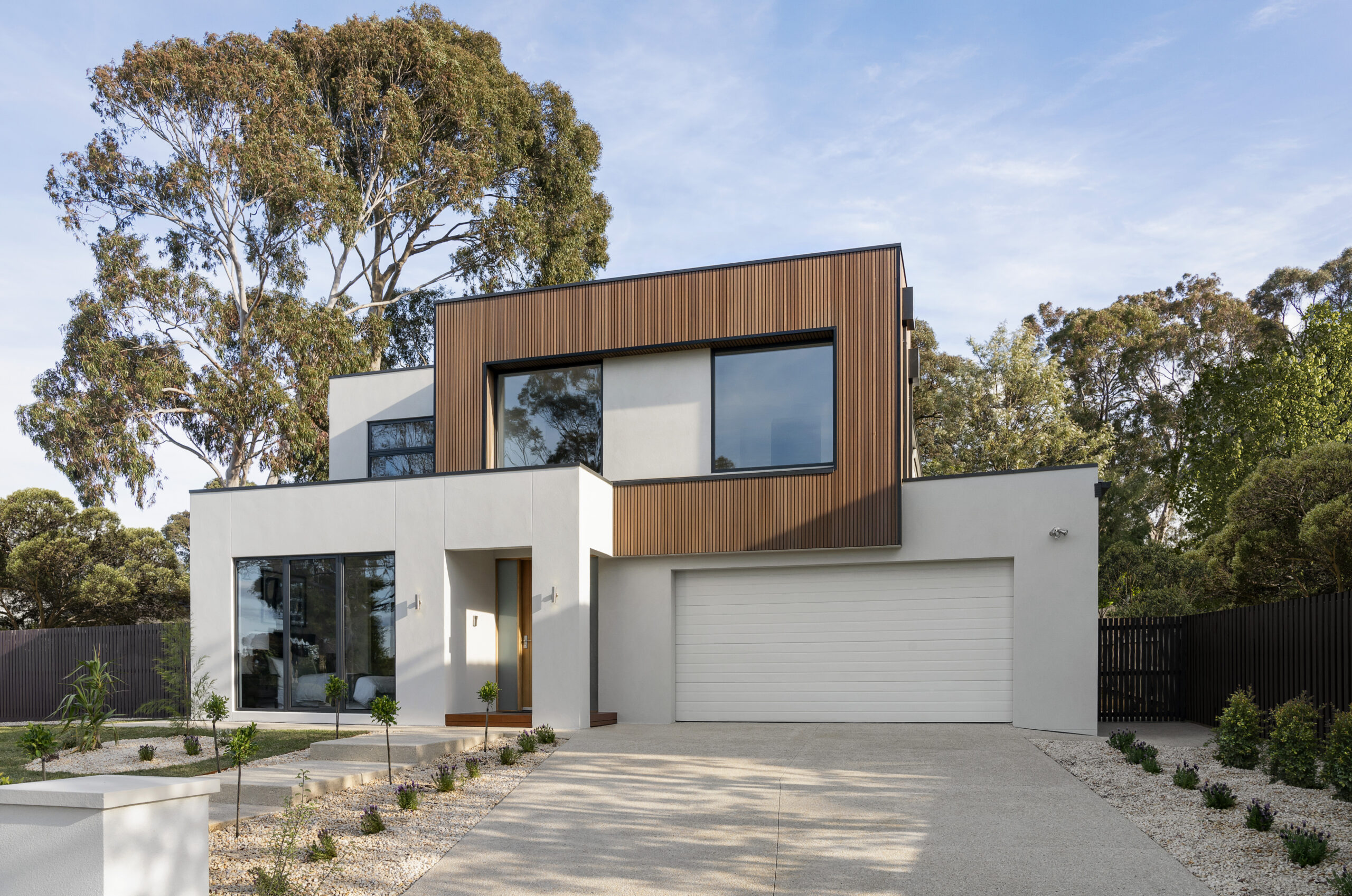 The façade of a pale double-storey Hebel home with light timber cladding.