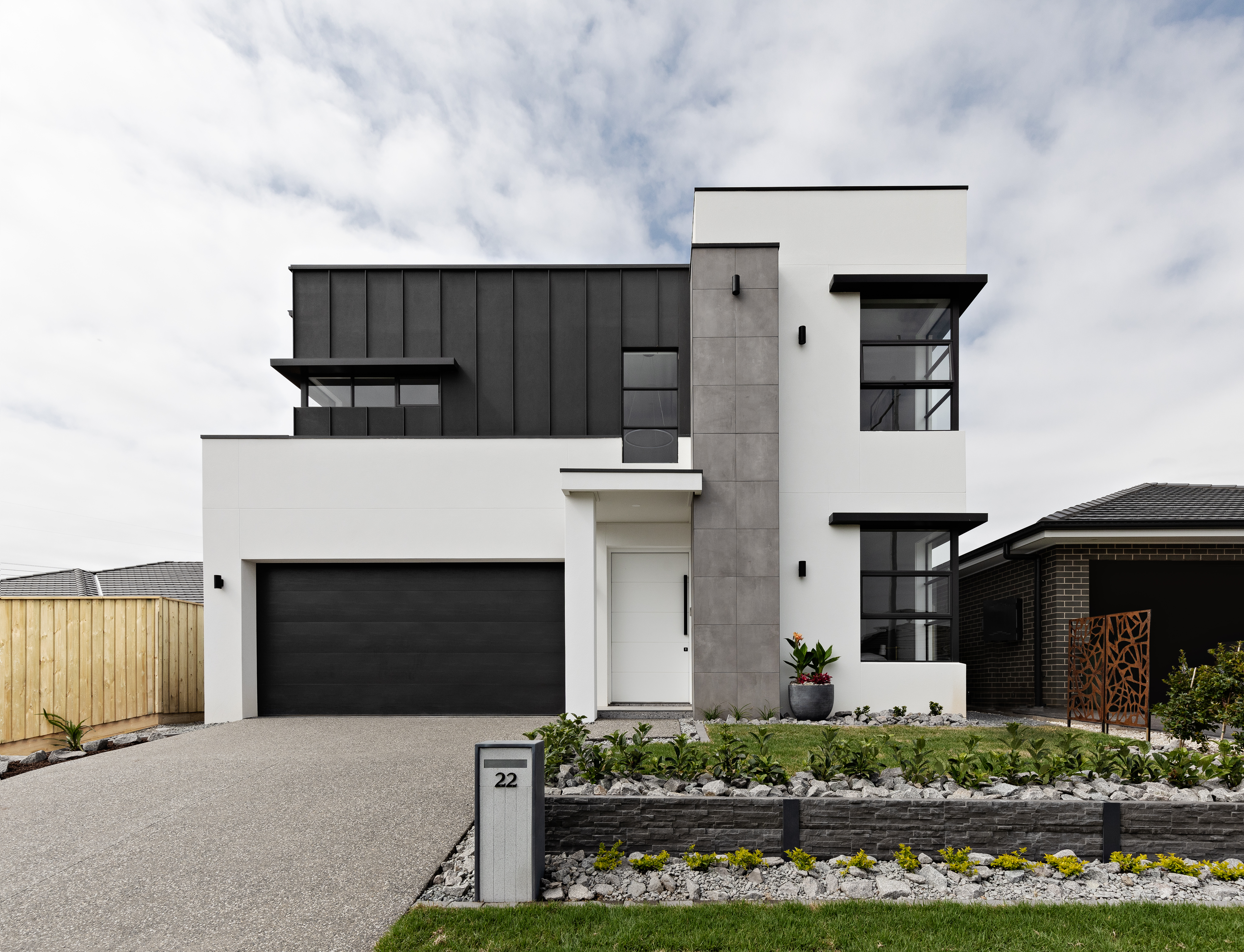 The façade of a double storey home featuring rendered Hebel PowerProfile and dark grey and charcoal accents.